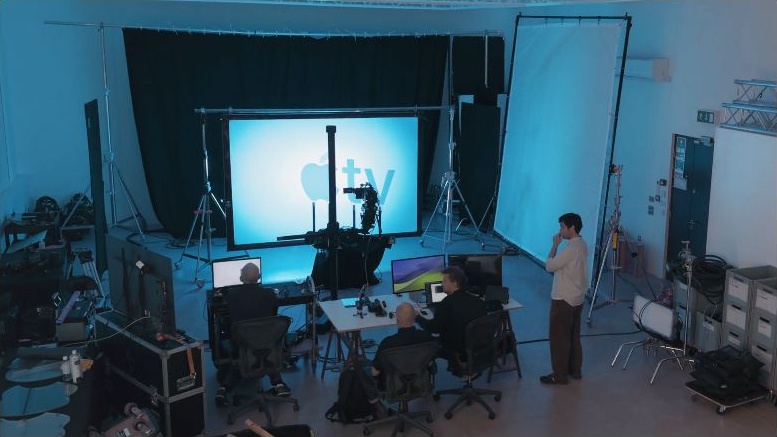 Frame dos bastidores oficiais Apple TV: câmera, equipe e instalação física de estúdio.